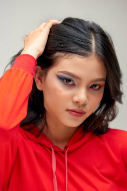 Güzel, parlak, sanatsal makyajlı ve kısa saçlı, gülümseyen muhteşem genç bir kadının yakın portresi.