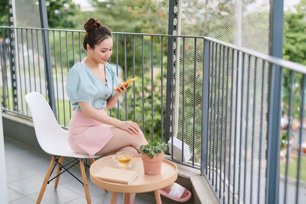 Bella Ragazza Che Colazione Sul Balcone Mentre Utilizza Suo Telefono — Foto Stock