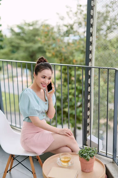 Felice Giovane Donna Asiatica Utilizzando Telefono Quando Seduto Bere Balcone — Foto Stock