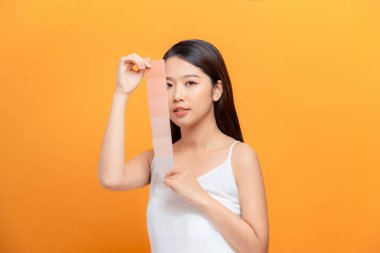 Güzel bayan Asyalı güzellik ve bronzlaşmış ten UVA arka plan sarısı için