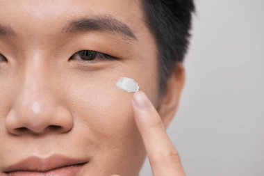 Genç yakışıklı beyaz krema kullanıyor.