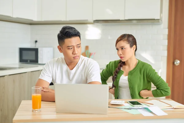 Upset young couple with financial bills having conflict at home