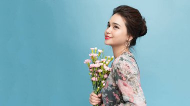 Güzel narin kadın bahar çiçeklerini kokluyor.