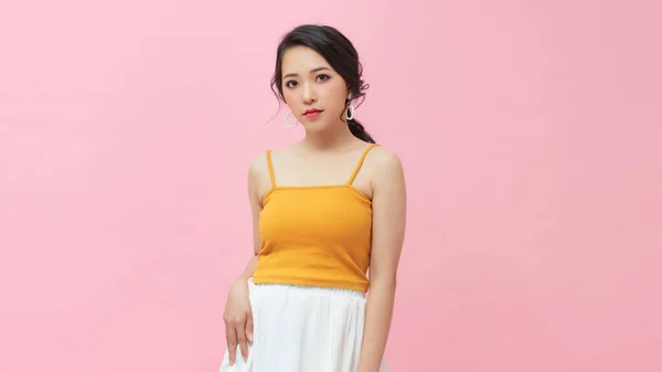 アジアの若い女性の半分の長さの肖像画ピンクのスタジオの背景 — ストック写真