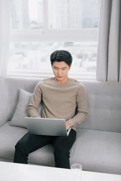 Young Man Smiling Reads Screen Laptop Computer While Relaxing Comfortable — Stock Photo, Image