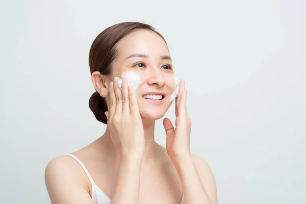 用日常护理的皮肤清洁剂洗净泡沫 让笑容满面的亚洲女人显得开心 — 图库照片