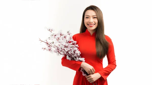 亚洲女人穿着红色的传统越南服装站在那里 手握桃花枝头 感到快乐和希望 — 图库照片