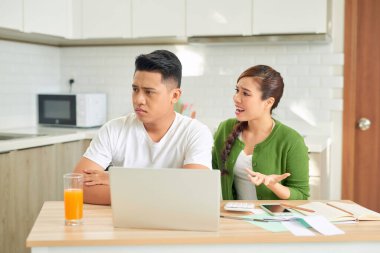 Oturma odasında ödenmemiş faturaları olan kavga eden genç bir çift.