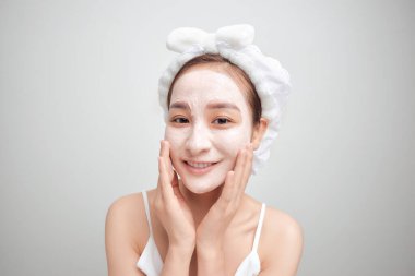 Beyaz yüz kilinden maskeli çekici bir Asyalı kadın. Güzellik merkezi konsepti