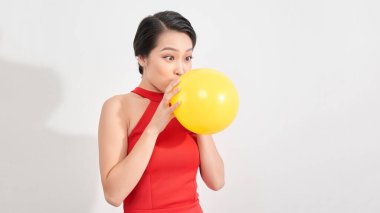 Moda güzeli kız sarı bir balon şişiriyor. Muhteşem Kadın Portresi. Şık Saç ve Makyaj