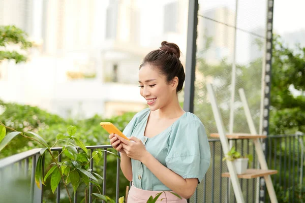 Feliz Chica Asiática Joven Hablando Por Teléfono Cuando Está Pie —  Fotos de Stock