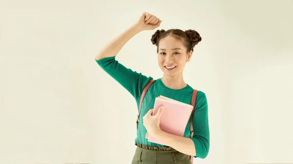 Young woman holding pink book. Isolated studio portrait.