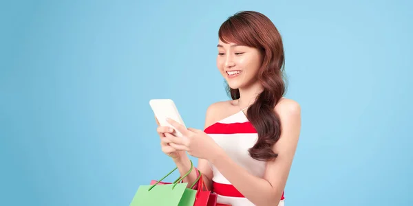 Hermosa Chica Está Sosteniendo Bolsas Compras Utilizando Teléfono Inteligente Sonriendo — Foto de Stock