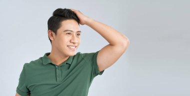 Asyalı adam, karantina sonrası yeni saç kesimini kontrol ediyor..