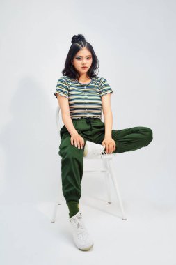 Güzel bir kadının tam boy portresi bir sandalyeye oturur. Stüdyo çekimi