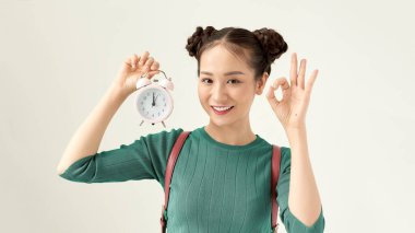 Young beautiful woman holding vintage alarm clock over isolated white background doing ok sign with fingers, excellent symbol