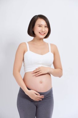 Güzel bir Asyalı kadın karnına dokunuyor. Hamilelik ve beklenti konsepti