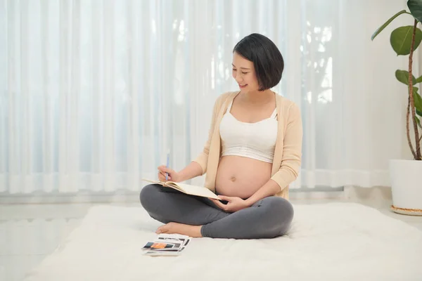 Frau Legt Sich Hin Und Betrachtet Ultraschallbild Ihres Ungeborenen Babys — Stockfoto