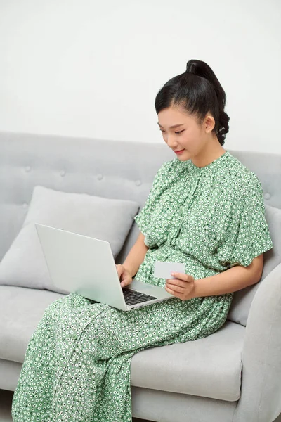 아시아 어머니가 집에서 노트북 컴퓨터와 카드를 사용하여 아기의 주문하는 — 스톡 사진