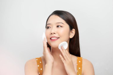 Gülen kadın beyaz arka planda pamuk tutuyordu. Cilt bakımı kavramı.