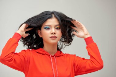 Güzel, parlak, sanatsal makyajlı ve kısa saçlı, gülümseyen muhteşem genç bir kadının yakın portresi.