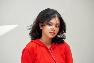 Ciltli, kıvırcık saçlı, parlak makyajlı güzel bir kadın.