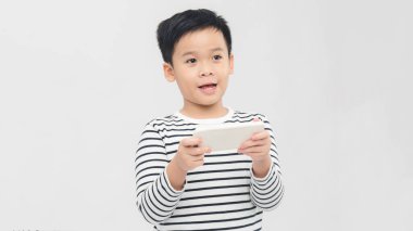 Akıllı telefondan stüdyoda poz veren komik küçük çocuk.