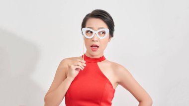 Güzel görünümlü genç bir kızın portresi. Partiye yüz maskesi takılı sopayla katılıyor. Gülümsüyor.