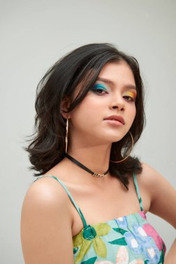 Neşeli genç kız eğleniyor. Beyaz arka planda parlak makyajlı gülümseyen kadın.