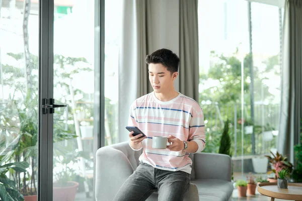 Handsome Young Man Checking His Messages While Drinking Coffee Home — Stock Photo, Image