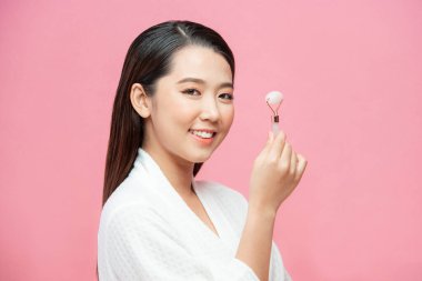 Güzellik yüz bakımı. Kadın evinde spa cilt bakımı için gül kuvars ile yüz masajı yapıyor.