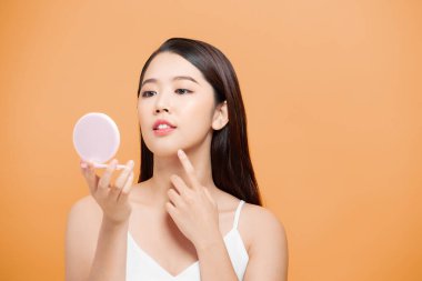 Güzel bir kadın aynanın önünde kendine gelir.