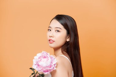 Pembe çiçekli güzel bir kadın, sarıda soyutlanmış.