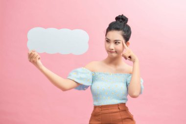 Boş konuşma balonu tutan heyecanlı bir genç kadının portresi ve pembe arka plan üzerinde izole edilmiş bir parmak.
