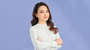 Mor bir arka planda kollarını kavuşturmuş mutlu bir kadının portresi.