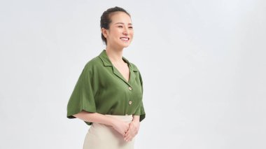 Güzel görünümlü Asyalı bir kadının portresi. Yan tarafa bakıp, beyaz arka planda dikilirken gülüyor.. 