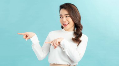 Parmakla işaret eden gülümseyen kadın. Beyaz üzerine izole edilmiş portre.