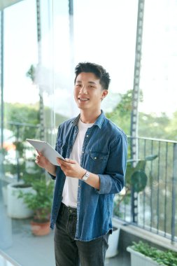 Sunny Day, Man Standing and Browsing in Tablet in Balkon, Gadget