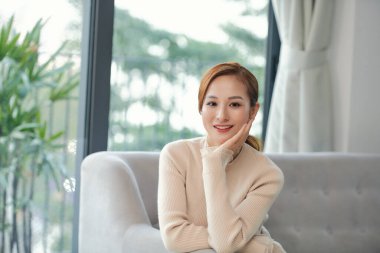 Rahatlamış sakin kadın dinleniyor temiz hava alıyor zihinsel dengeyi hissediyor evinde, kanepede keyfine bakıyor.