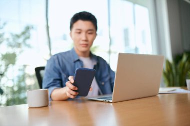 İş adamı kahve dükkanında çalışırken telefonu kullanıyor.