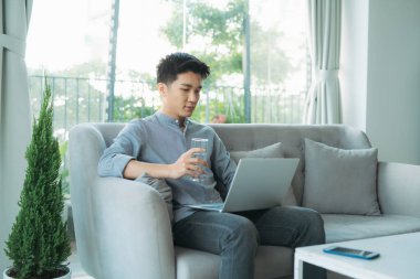 Bilgisayarda internet bağlantısı olan yakışıklı bir genç çocuk.