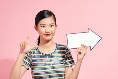 Sağ tarafını gösteren mavi bir ok tutan güzel bir kadın.