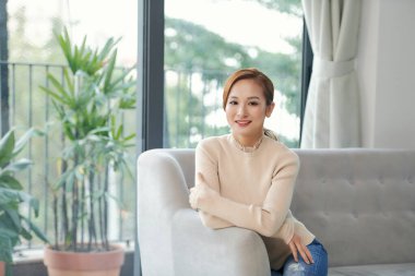 Rahatlamış sakin kadın dinleniyor temiz hava alıyor zihinsel dengeyi hissediyor evinde, kanepede keyfine bakıyor.