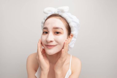 Bir kadın duştan sonra yüzüne maske takmış.