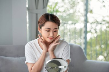 Mutlu genç kadın elleriyle yüzüne dokunuyor.