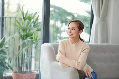 Tatmin olmuş genç bir bayan stresten zevk alıyor. Haftasonu sabahları kanepeye uzanıyor.