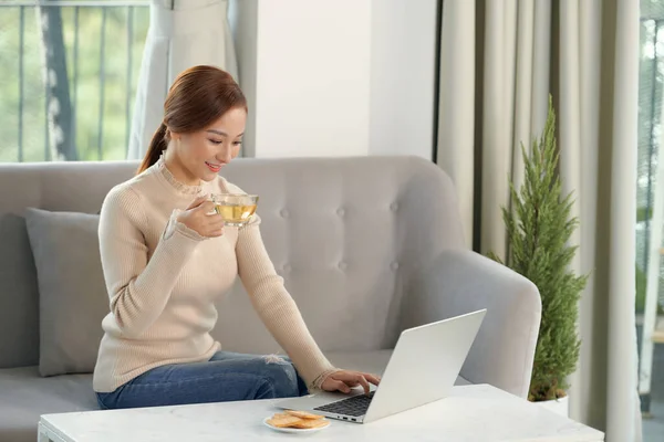 Schöne Fröhliche Rothaarige Mädchen Mit Silbernem Laptop Während Sie Hause — Stockfoto