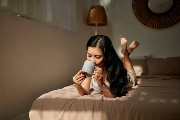 Schöne Junge Frau Mit Kaffeebecher Der Hand Auf Dem Bett — Stockfoto
