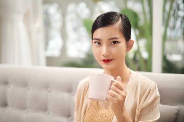 çekici genç bayan evde kahve içiyor.