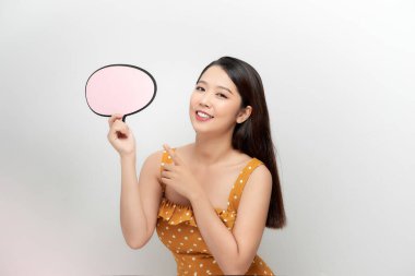 Kadın işaret dili pankartı gösteriyor. Mutlu görünüyor ve parmağıyla işaret ediyor.